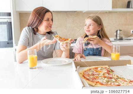 Mother and daughter eating a tasty pizza 106027754