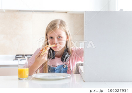 little girl eating pizza sitting at the table little girl eating pizza sitting at the table 106027954