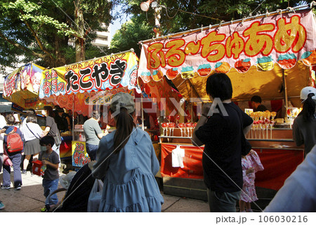 祭り囃子を聞きながら縁日の露店で食べ歩く。年に一度の祭りでウキウキしながら 106030216