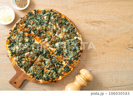 spinach and cheese pizza on wood tray 106030583