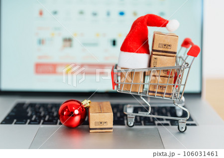 Christmas Online Shopping concept. Boxes with shopping cart on a laptop computer. Sale and discount during Christmas and New Year holiday, ecommerce, shipping delivery, logistics and Cyber Monday 106031461