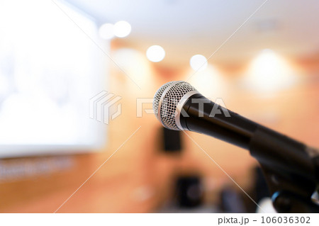 Wired microphone set up on the front of conference room close up with blurred background. Wired microphone close up with copy space background. Wired microphone set up on the front of conference room close up with blurred background. Wired microphone close up with copy space background. 106036302