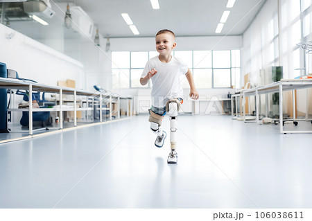 Happy Child disabled boy with prostheses instead of legs trains in a rehabilitation center. 106038611