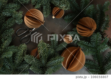 Christmas toys made of paper. Handmade work. Craft paper. Spruce branches. Vertical photo. Greeting card for holiday. New Year or Christmas. Christmas toys made of paper. Handmade work. Craft paper. Spruce branches. Vertical photo. Greeting card for holiday. New Year or Christmas. 106038807