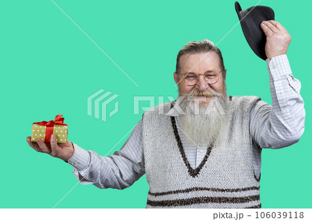 Portrait of senior aged grandpa raising up his hat. Isolated on green. Portrait of senior aged grandpa raising up his hat. Isolated on green. 106039118