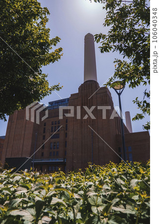 View of new Battersea Power Station amidst plants. Exterior of office building with sky in background. Tourist attraction in London during sunny day. 106040348