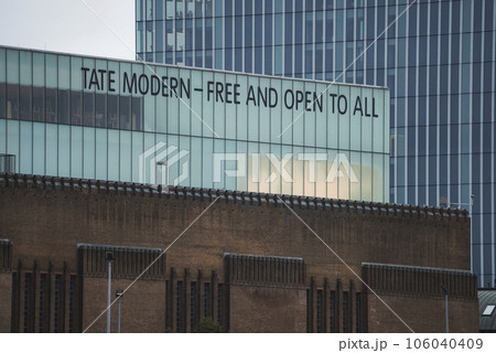 Close up of text on Tate Modern in background. Popular modern art exhibition on riverbank in city. Famous urban architectural beauty in London. Close up of text on Tate Modern in background. Popular modern art exhibition on riverbank in city. Famous urban architectural beauty in London. 106040409