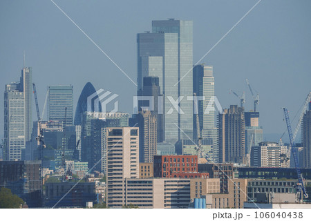 Modern tall skyscrapers amidst residential district. Scenic view of city with blue sky in background. High angle view of urban development in London. Modern tall skyscrapers amidst residential district. Scenic view of city with blue sky in background. High angle view of urban development in London. 106040438