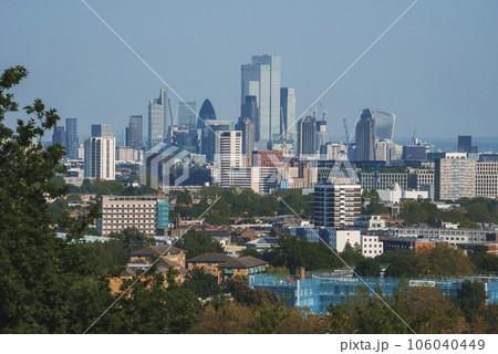 Modern skyscraper amidst residential district. Scenic view of crowded city with blue sky in background. High angle view of modern development in London. Modern skyscraper amidst residential district. Scenic view of crowded city with blue sky in background. High angle view of modern development in London. 106040449