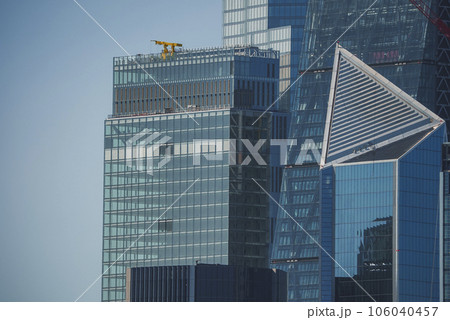 View of modern skyscrapers in city. Financial office building with blue sky in background. Glass windows on modern structure in downtown district of London. View of modern skyscrapers in city. Financial office building with blue sky in background. Glass windows on modern structure in downtown district of London. 106040457