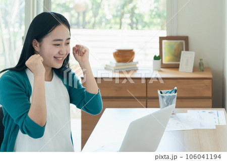 パソコンの前で喜ぶ若い女性 パソコンの前で喜ぶ若い女性 106041194