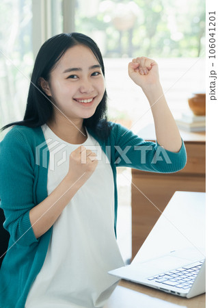 パソコンの前で喜ぶ若い女性 パソコンの前で喜ぶ若い女性 106041201