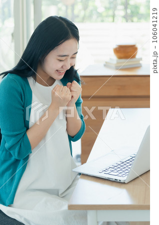 パソコンの前で喜ぶ若い女性 パソコンの前で喜ぶ若い女性 106041219