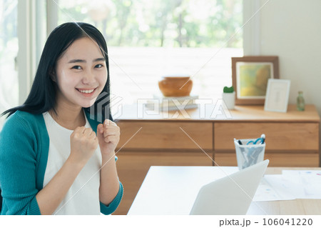 パソコンの前で喜ぶ若い女性 106041220