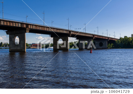 Bridge on a river against a blue sky and clouds Bridge on a river against a blue sky and clouds 106041729
