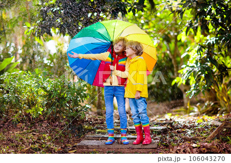 Child playing in autumn rain. Kid with umbrella. Child playing in autumn rain. Kid with umbrella. 106043270