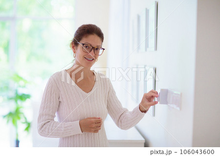 Woman adjusting thermostat. Central heating. Woman adjusting thermostat. Central heating. 106043600