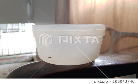 closeup view of an old white plastic bowl isolated on wooden background closeup view of an old white plastic bowl isolated on wooden background 106043740