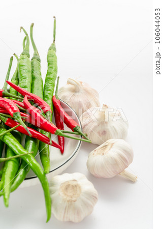 Red chili pepper, green chili pepper, onion, and garlic on a white background. 106044053