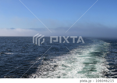 Ship's wake with Port Angeles, Olympic Mountains and fog bank in background. Ship's wake with Port Angeles, Olympic Mountains and fog bank in background. 106046215