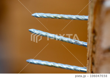 Group of three nails thru a crate close up 106047038