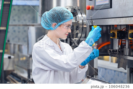 Bottling factory worker inspecting quality of water bottles before shipment. Reverse osmosis system used in plant. water purity and maintaining quality control in bottling process. High quality photo Bottling factory worker inspecting quality of water bottles before shipment. Reverse osmosis system used in plant. water purity and maintaining quality control in bottling process. High quality photo 106048236
