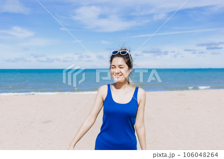 Happy and cheerful woman in blue dress on the sunny beach of Thailand. 106048264