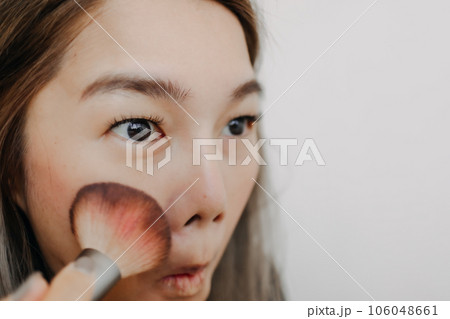 Close up of woman brushing her cheek face for make up. 106048661