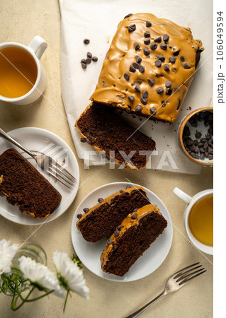 Chocolate loaf cake with coffee icing and chocolate chips, top view. Chocolate loaf cake with coffee icing and chocolate chips, top view. 106049594