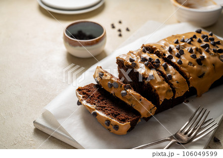 Chocolate loaf pound cake slices with coffee icing and chocolate chips, top view. Chocolate loaf pound cake slices with coffee icing and chocolate chips, top view. 106049599