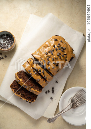 Chocolate loaf pound cake slices with coffee icing and chocolate chips, top view. Chocolate loaf pound cake slices with coffee icing and chocolate chips, top view. 106049601