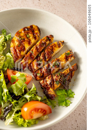 Grilled chicken breast with fresh salad in a plate. Grilled chicken breast with fresh salad in a plate. 106049605