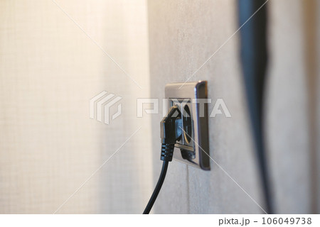 white color power cord cable plugged into wall white color power cord cable plugged into wall 106049738