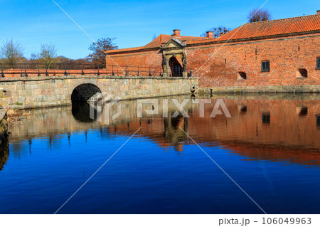 Brick stone bridge across the lake surrounding Frederiksborg castle in Hillerod, near Copenhagen, Denmark 106049963
