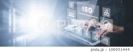 Hand hold Laptop with ISO standards quality control concept, assurance warranty in dark background, Cogs and gear wheel mechanisms, identification information security and encryption, secure access 106051444