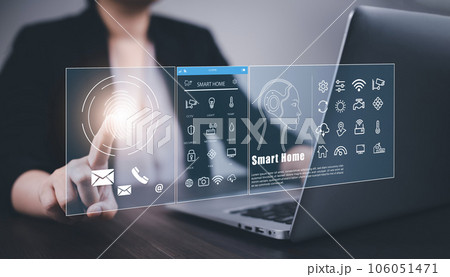 Hand using AI smart tablet with smart home app on the room, circular interface of the smart home automation assistant on the virtual screen and user touches the button, smart home digital interface 106051471