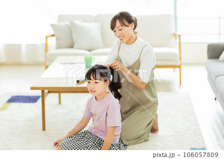 母親に髪をブラッシングしてもらう女の子 母親に髪をブラッシングしてもらう女の子 106057809