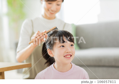 母親に髪をブラッシングしてもらう女の子 母親に髪をブラッシングしてもらう女の子 106057811