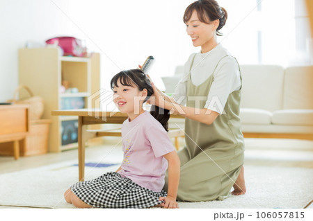 母親に髪をブラッシングしてもらう女の子 106057815