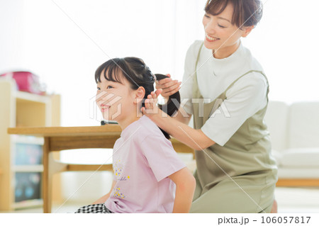 母親に髪をブラッシングしてもらう女の子 106057817