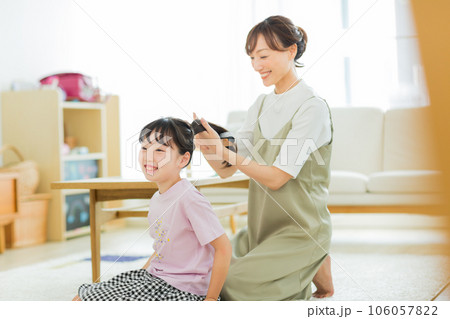 母親に髪をブラッシングしてもらう女の子 106057822