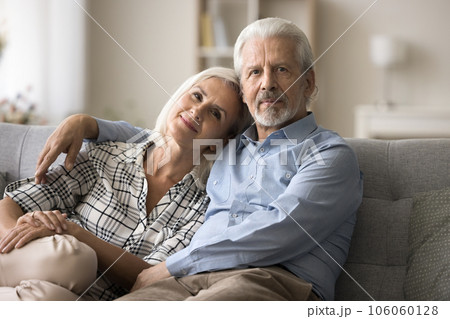 Confident senior couple in love posing on home sofa Confident senior couple in love posing on home sofa 106060128