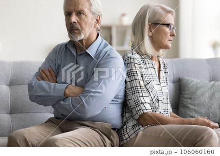 Offended husband and mad wife sitting with back touch 106060160