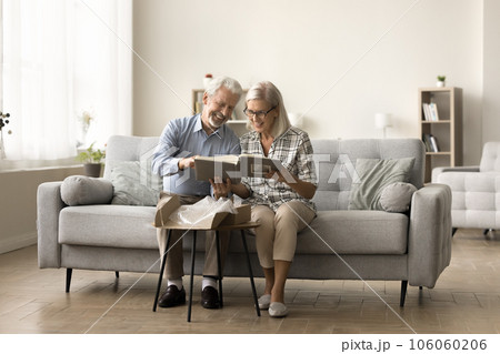 Happy senior married couple taking photo album 106060206