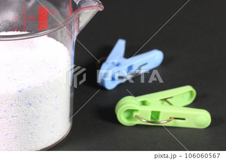 計量カップに入った粉せっけんと洗濯バサミ 106060567