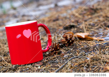 Red ceramic cup inscription love with hot drink beverage,autumn grass 106061086