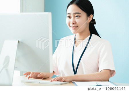 パソコン作業をする医療系女性スタッフ 106061143