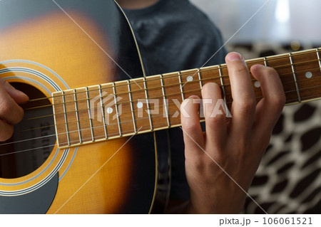 Man plays an acoustic guitar at home, close-up. Selective focus 106061521