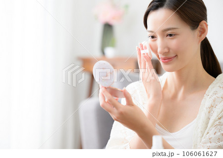 化粧の仕上げをする美しい女性の写真	 106061627