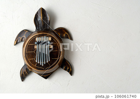 Kalimba turtle .Traditional Kalimba made from wooden board with metal, play on hands. Copy space Kalimba turtle .Traditional Kalimba made from wooden board with metal, play on hands. Copy space 106061740